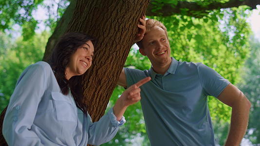 可爱的夫妇靠在树上说话靠得很近视频的预览图