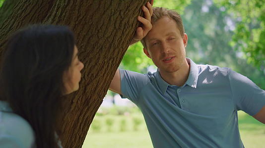 冷静的男人和妻子靠在树上说话视频的预览图