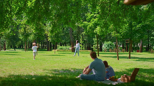 在野餐期间父亲和女儿一起看羽毛球比赛视频的预览图