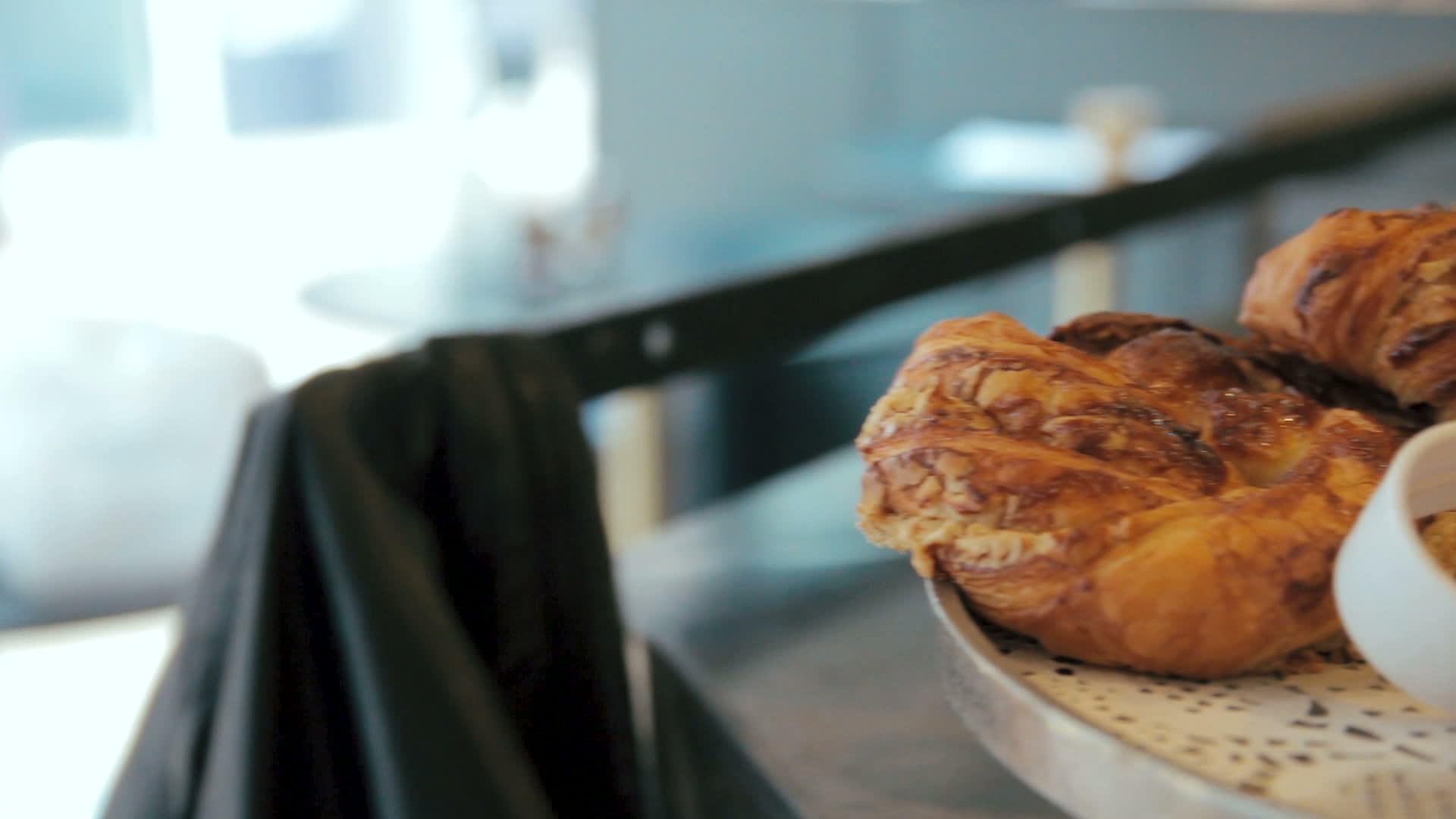 咖啡馆或面包店的托盘上有许多甜脆的羊角面包和小圆面包视频的预览图
