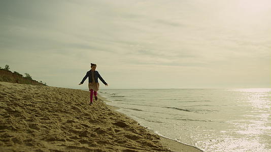 早晨可爱的孩子在海边跑视频的预览图