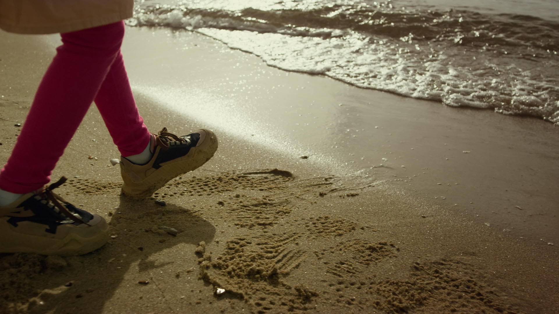 小女孩走在海边沙滩上的腿上视频的预览图