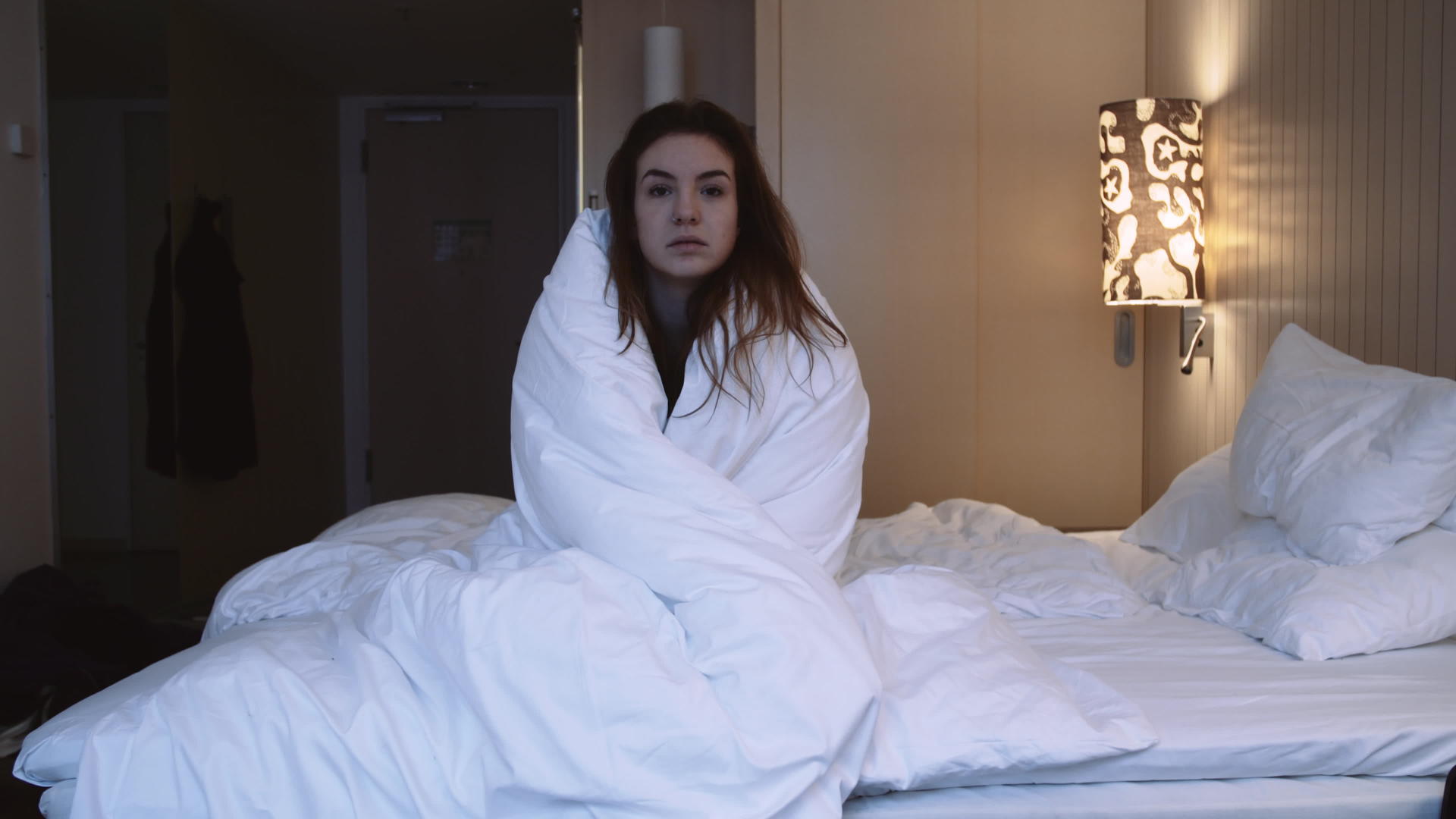 坐在床上的年轻女士用毯子裹着床视频的预览图