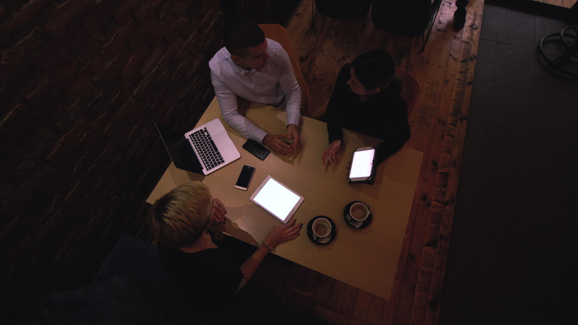深夜三位年轻的商业同事在一家现代咖啡馆成功会面视频的预览图