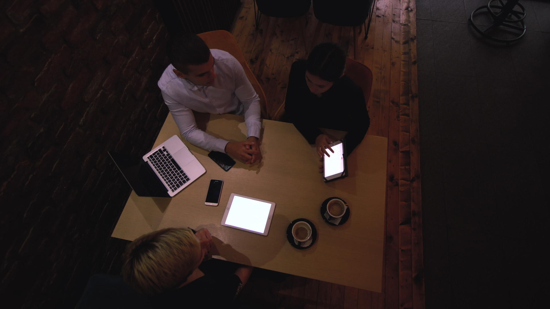 深夜三位年轻的商业同事在一家现代咖啡馆开会视频的预览图