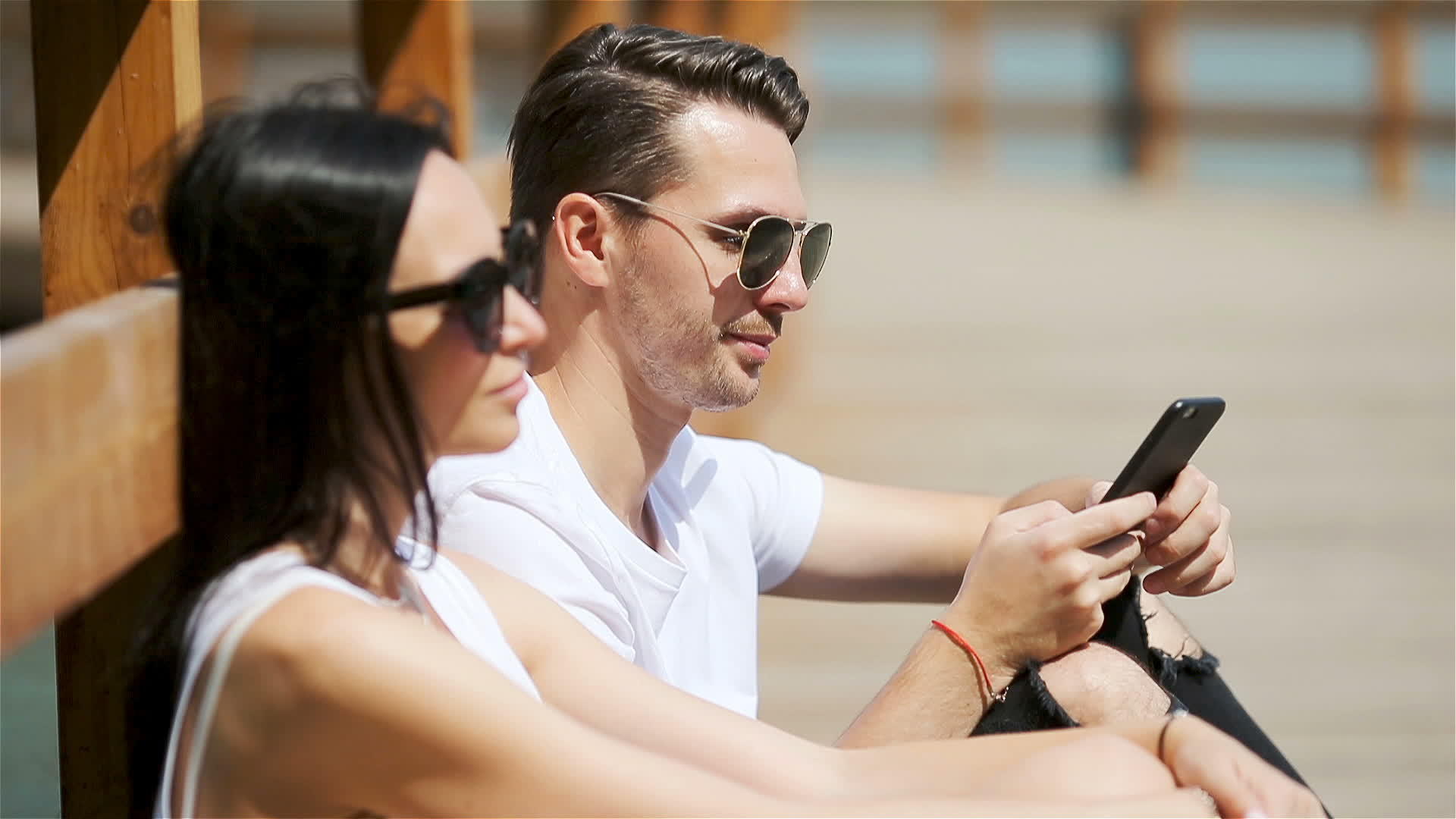 一对快乐情侣在公园里使用智能手机的照片视频的预览图