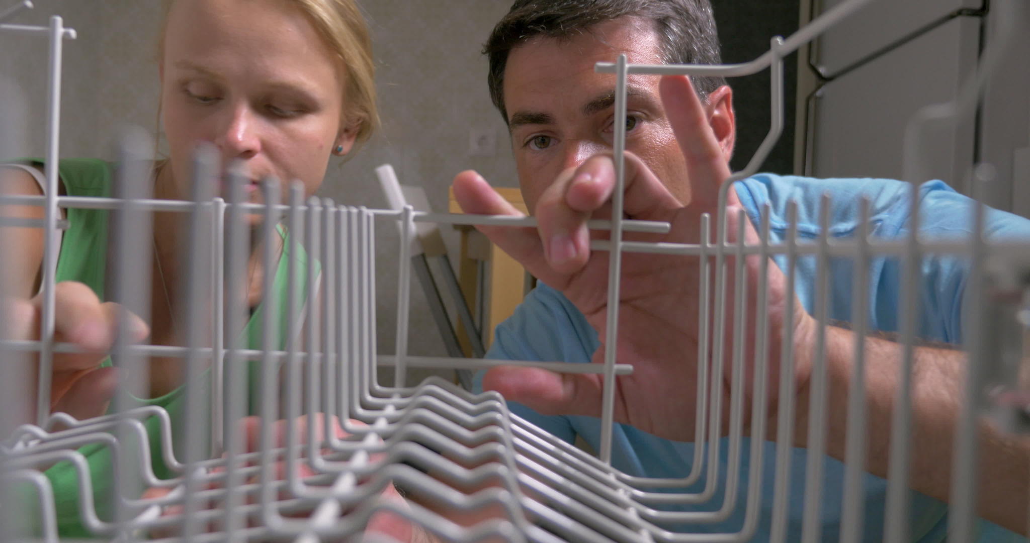 年轻夫妇打开洗碗机把盘子放在盘子里视频的预览图