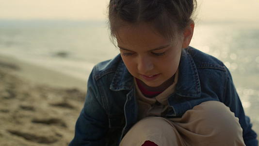 小姑娘在海边画沙子视频的预览图
