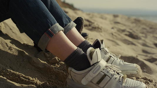 人的鞋子在沙滩上休息视频的预览图