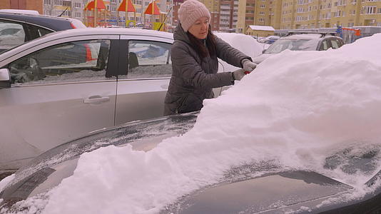 在公寓停车场洗雪的年轻女司机视频的预览图