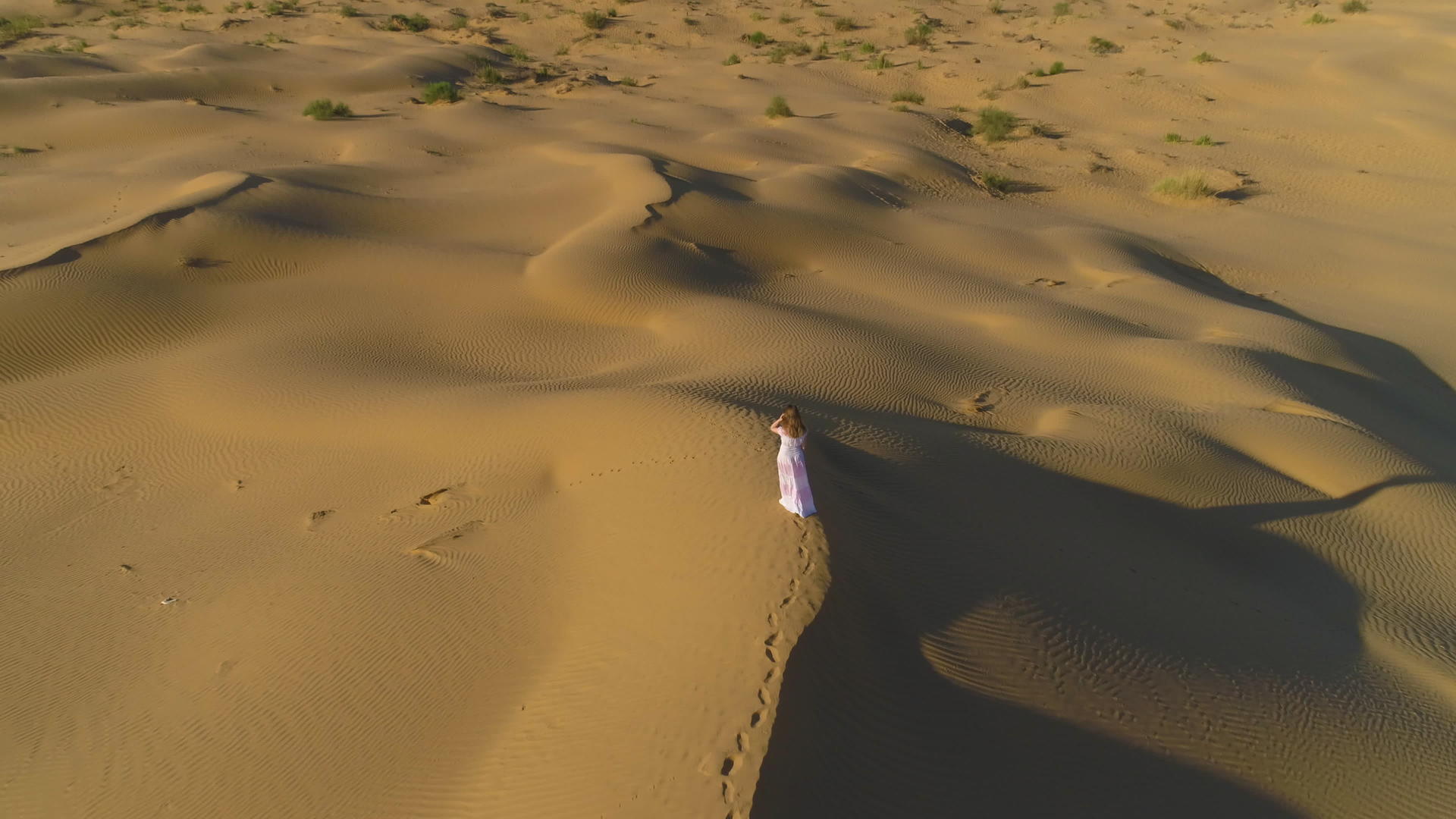 这位留着长发、穿着白色连衣裙的年轻孤独女子在沙漠中行走视频的预览图