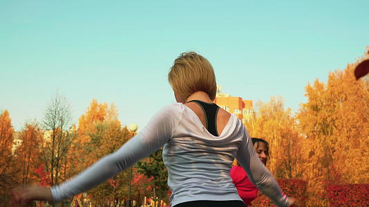 年轻女性在秋季公园训练瑜伽训练苗条的女性视频的预览图