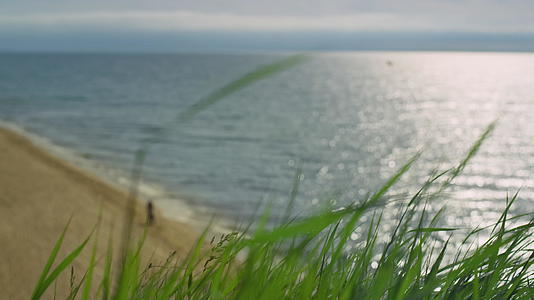 在自然景观背景下平静的海浪撞击沙滩视频的预览图