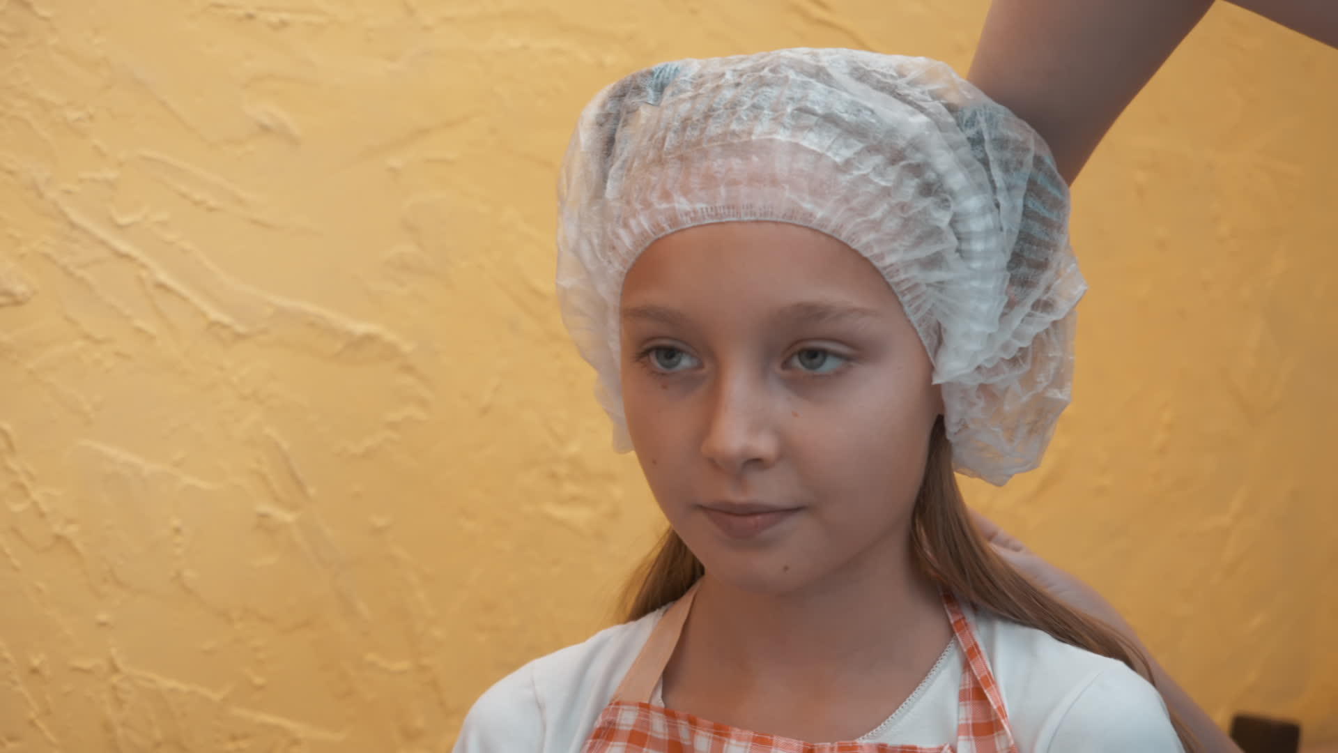 戴着一次性帽子和厨房围裙的年轻女厨师视频的预览图