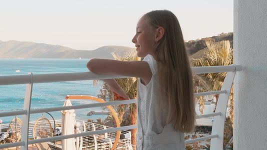 站在阳台度假酒店的少女十几岁的少女在酒店观赏海景视频的预览图