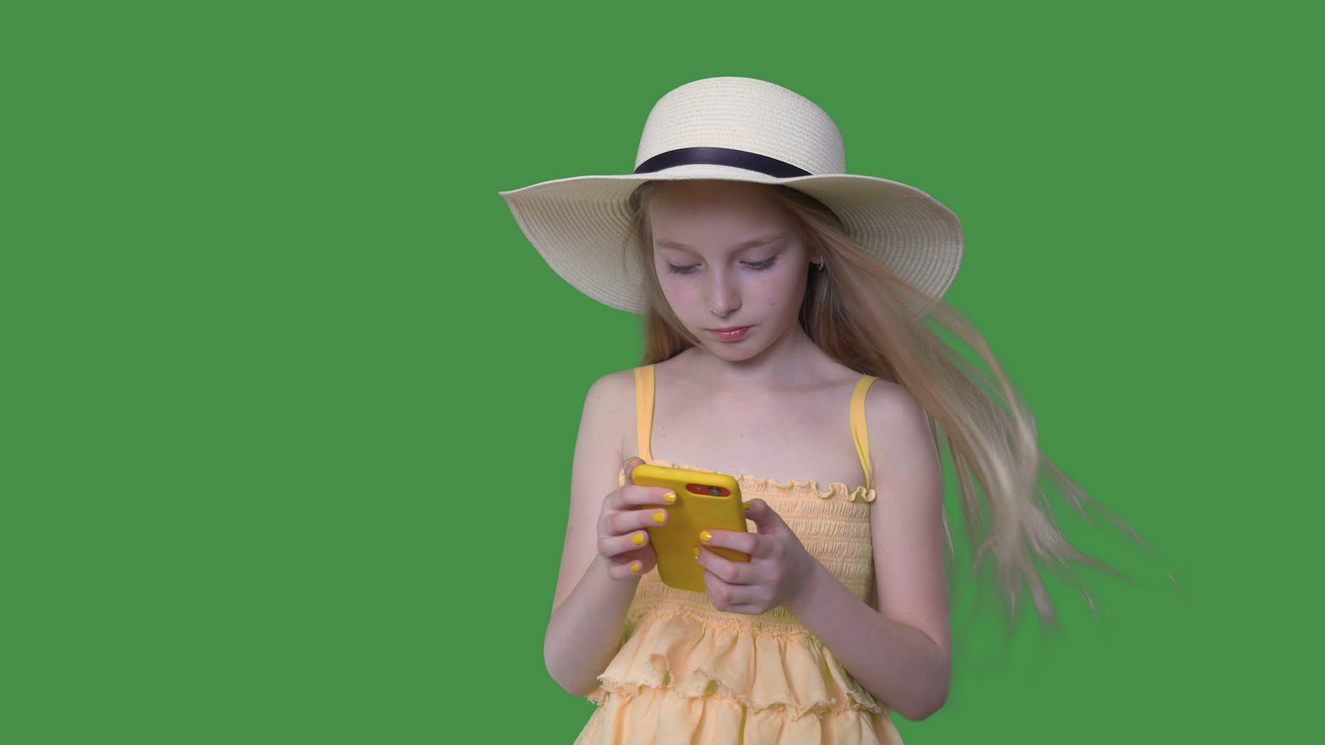 年轻女孩戴着帽子和黄色连衣裙在透明的绿色背景上使用视频的预览图