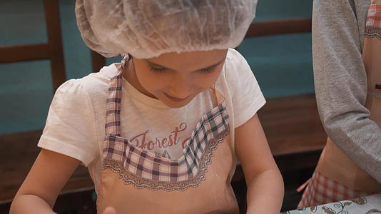 在烹饪学校的烹饪课上年轻女孩为意大利比萨面团感到高兴视频的预览图