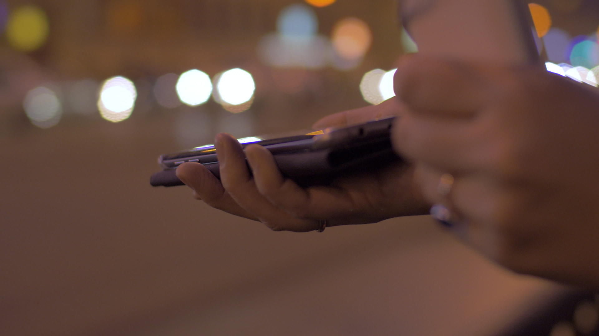 晚上街上的年轻女孩与移动电话便携式充电器连接视频的预览图
