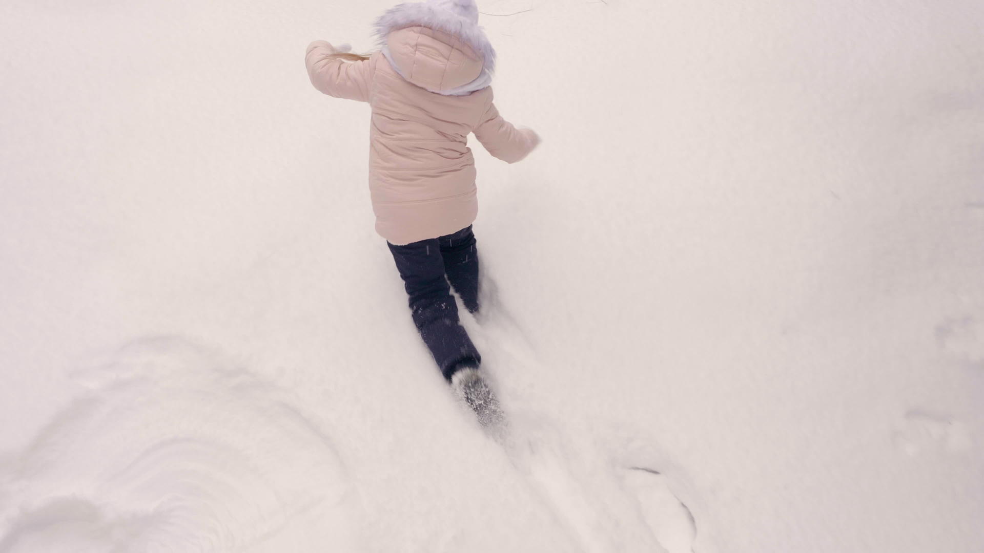 年轻女孩穿着珊瑚粉色夹克散步和下雪而不是展示雪天使视频的预览图