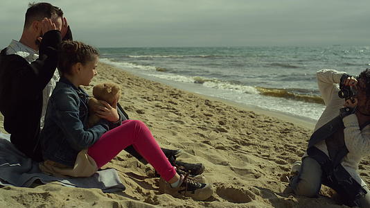 幸福的家庭在海洋沙滩上拍照视频的预览图