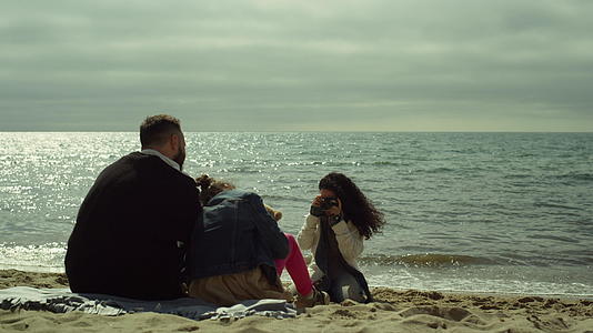 度假期间家人欣赏海滩照片视频的预览图