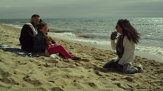 甜蜜的家庭在沙滩上合影留念视频的预览图