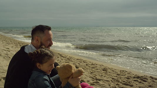 家庭团在阳光明媚的海滩上一起拍照视频的预览图