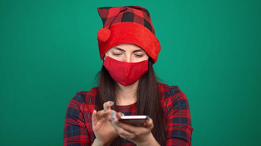 戴着圣达克萨斯帽的妇女在智能手机上戴着医用面具视频的预览图