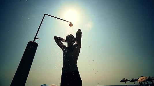 一个年轻人在海滩日落时慢慢地洗澡视频的预览图