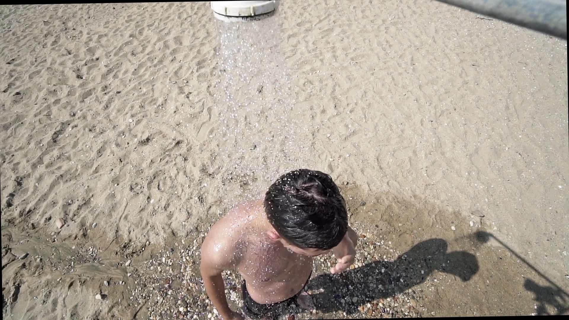 一个年轻人在沙滩上慢慢地洗澡视频的预览图