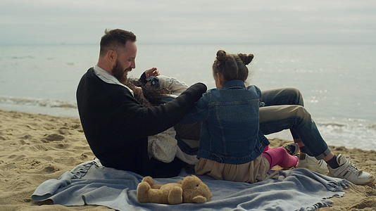 在沙滩上拥抱幸福的家庭小组视频的预览图