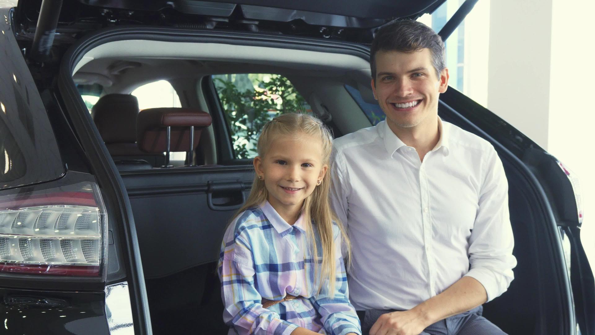 可爱的父亲和女儿坐在汽车后备箱上视频的预览图