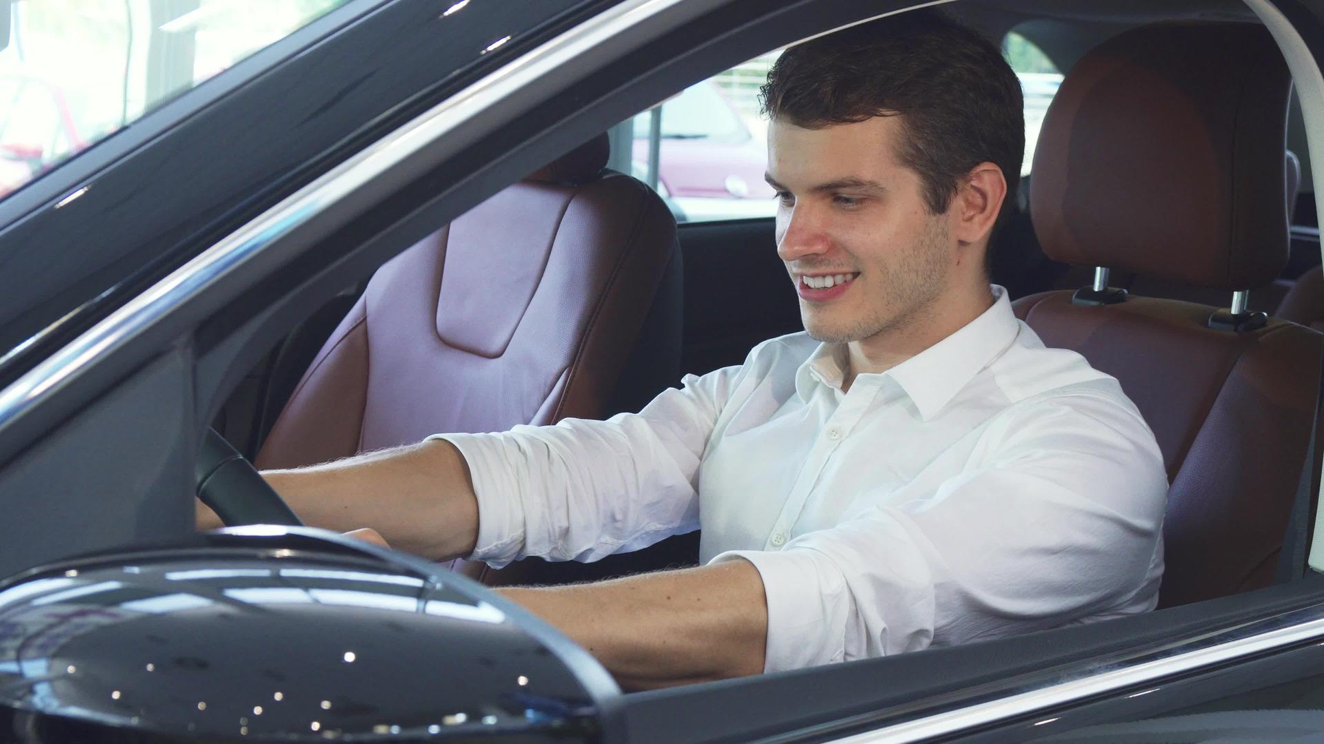 一个年轻人驾驶一辆新车的方向盘视频的预览图