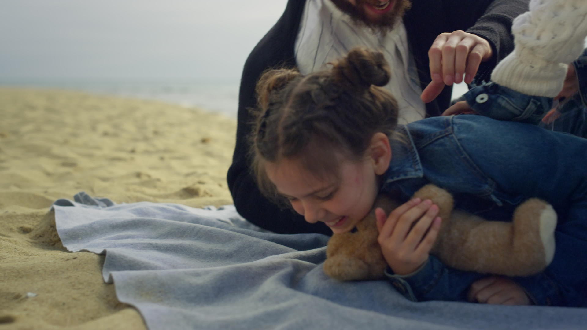 笑笑女孩在海滩上玩家庭视频的预览图