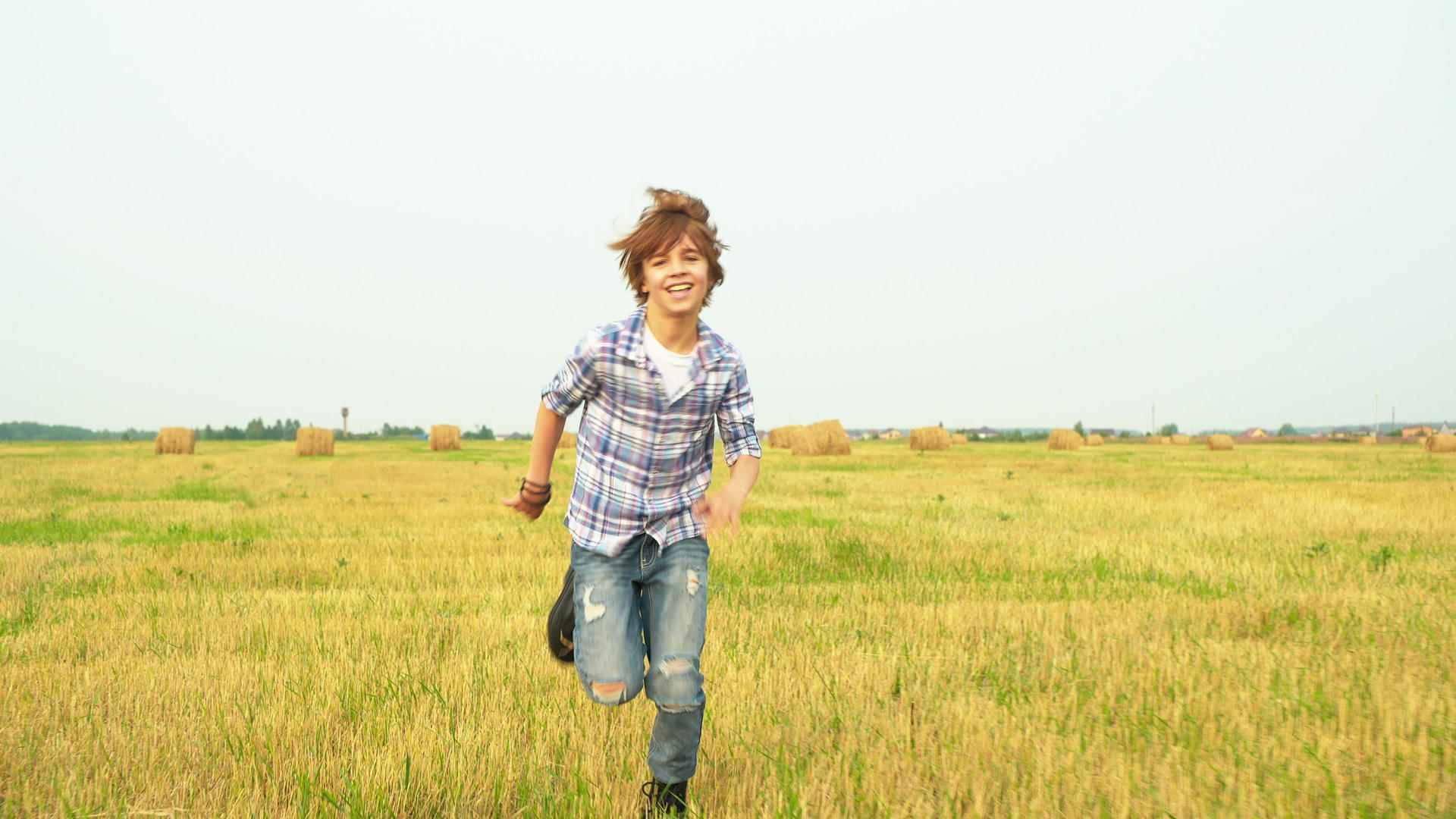 在村里干草堆的背景下微笑的男孩男孩视频的预览图