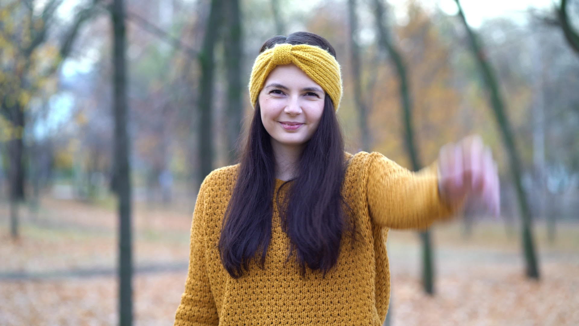 一个年轻女孩在秋天在公园里扔叶子视频的预览图