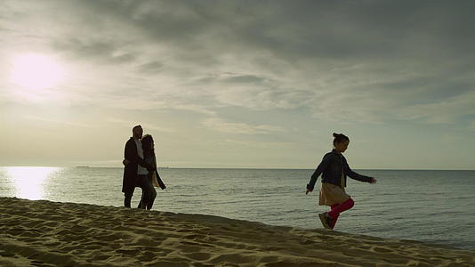 快乐的家庭步行海岸日落海滩视频的预览图