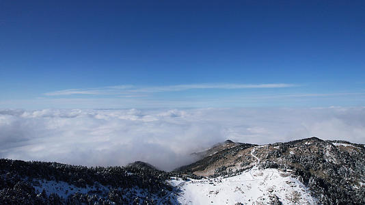 航拍冬天雪景湖北神农架积雪的山顶与翻腾的云海4k素材视频的预览图