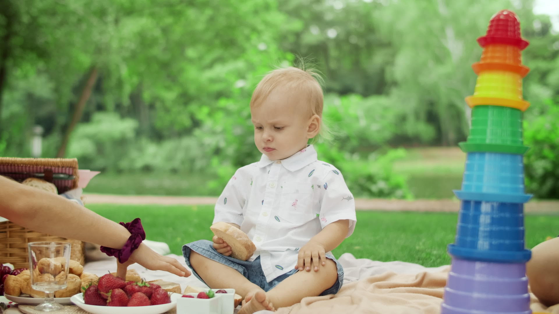 三个孩子坐在公园的毯子上视频的预览图