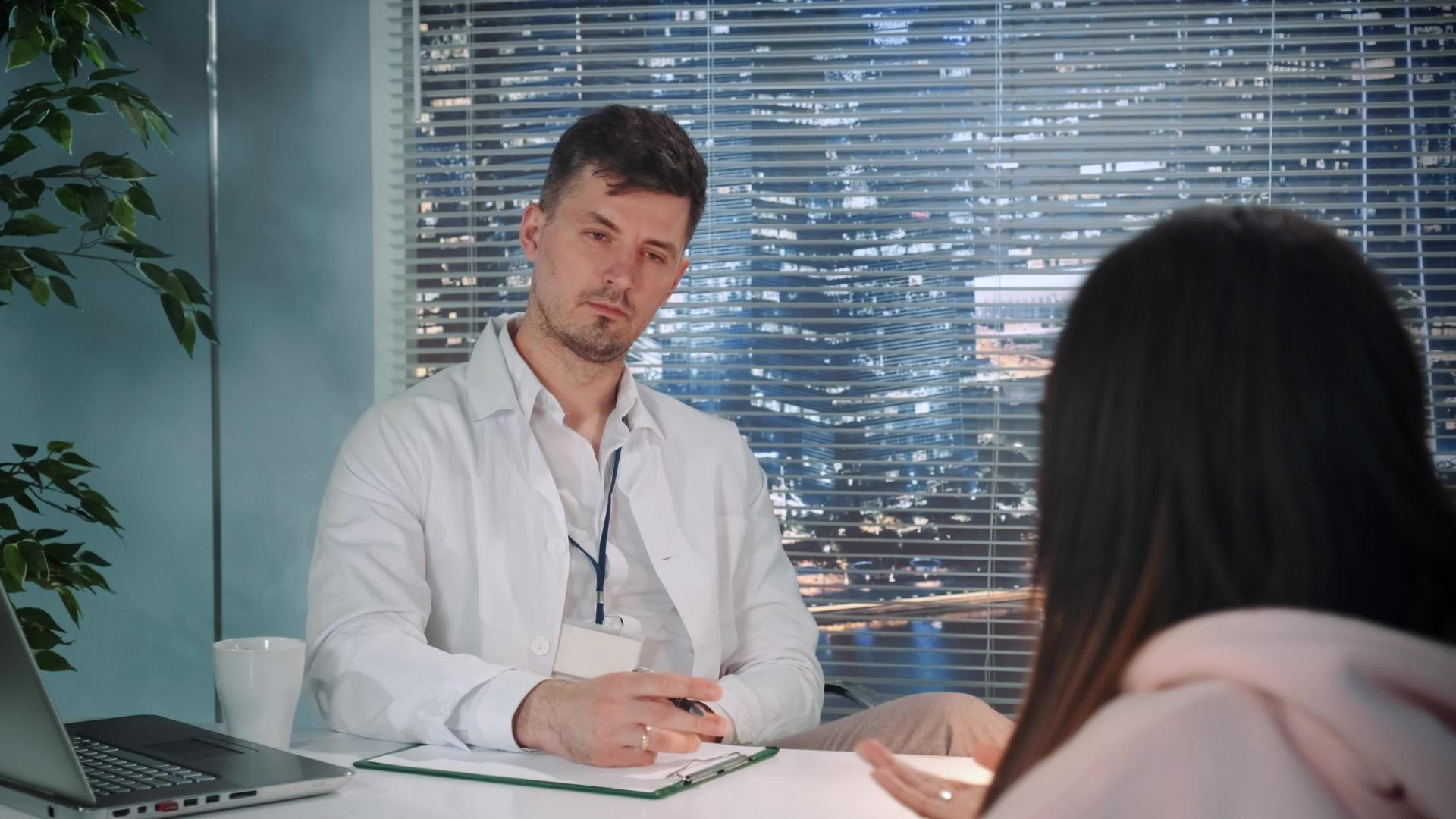 男性心理学家穿着外套听病人说话并做记录视频的预览图