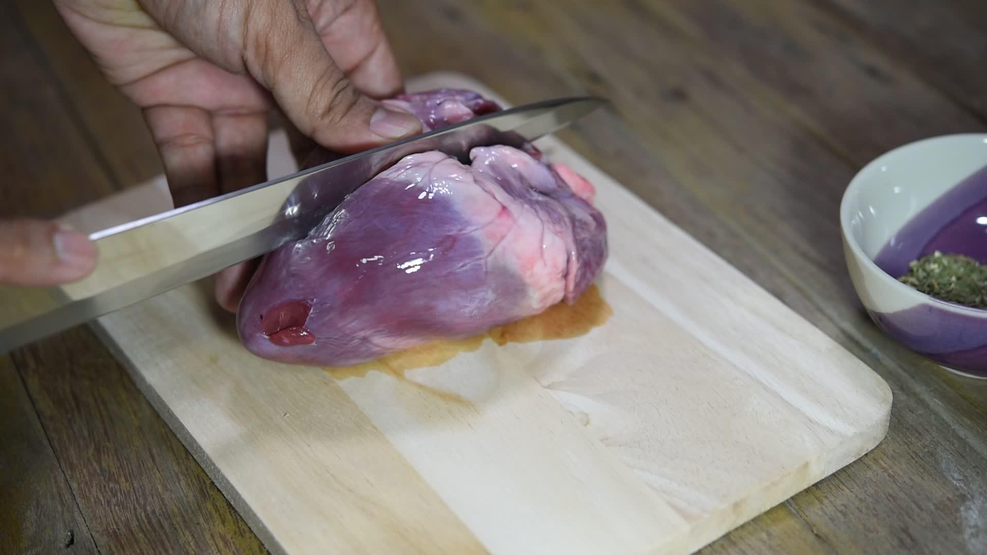 木质切割板上的新鲜猪心视频的预览图