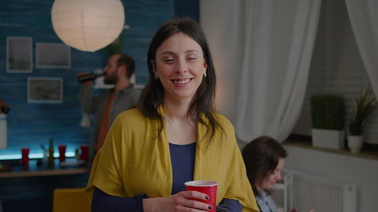 一个快乐的女人的肖像在她朋友快乐的背景下看着镜头视频的预览图
