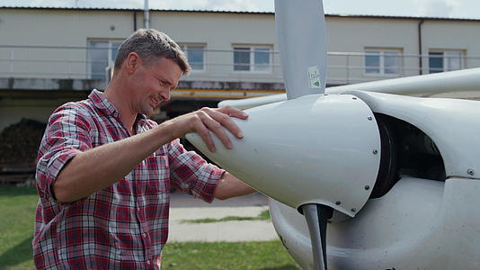 修理飞机螺旋桨的飞行员微笑着享受飞行前的过程视频的预览图