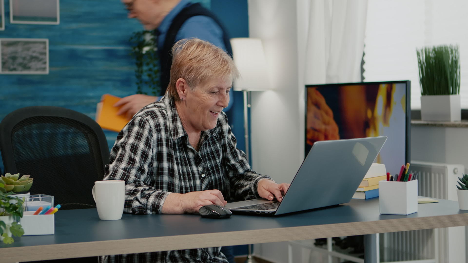 在家用笔记本电脑上收到好消息的老妇人视频的预览图