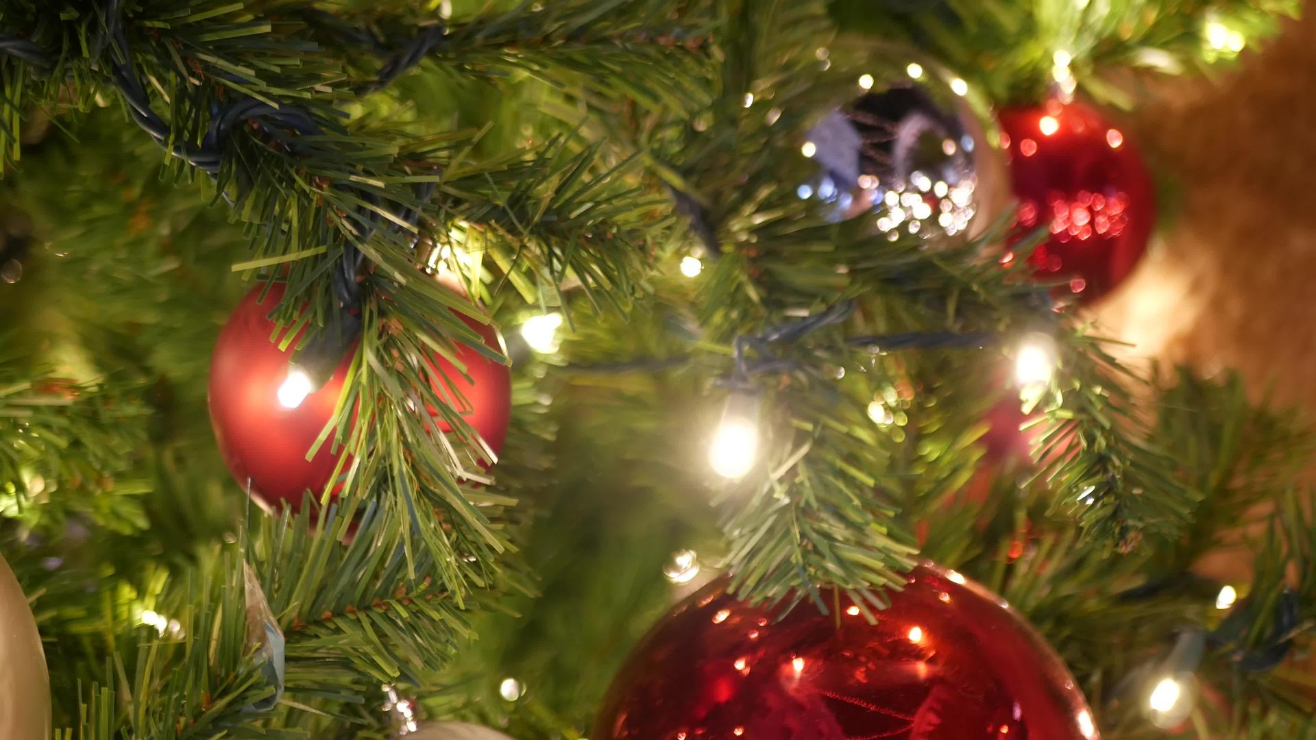 户外圣诞树节日装饰特写镜头和明亮的红色球模糊闪闪发光视频的预览图