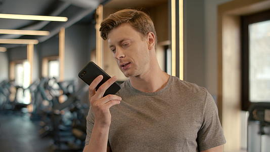 自信的运动员在健身房电话聊天视频的预览图