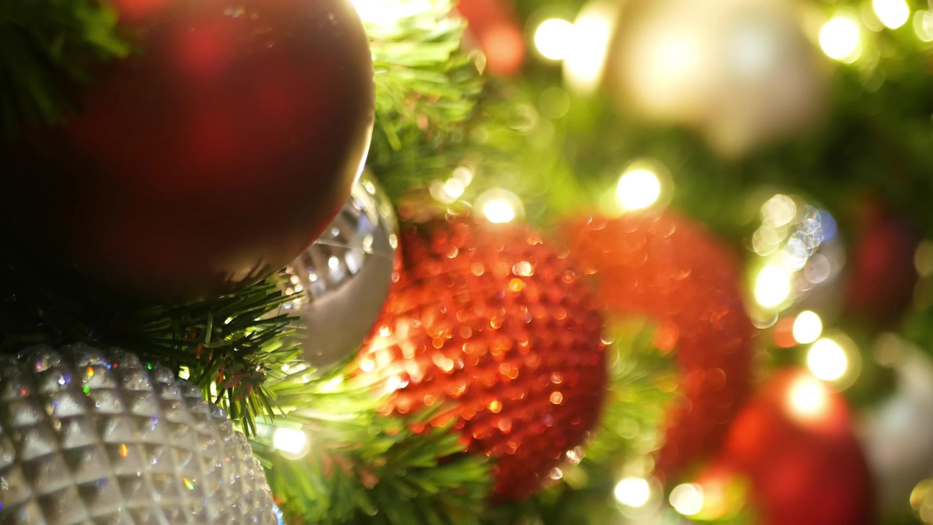 户外圣诞树节日装饰特写镜头和明亮的红色球模糊闪闪发光视频的预览图