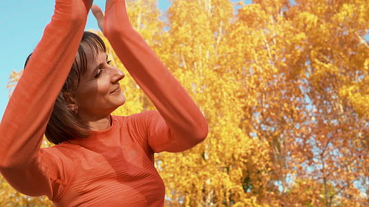 快乐的女人在秋天的公园里跳舞视频的预览图