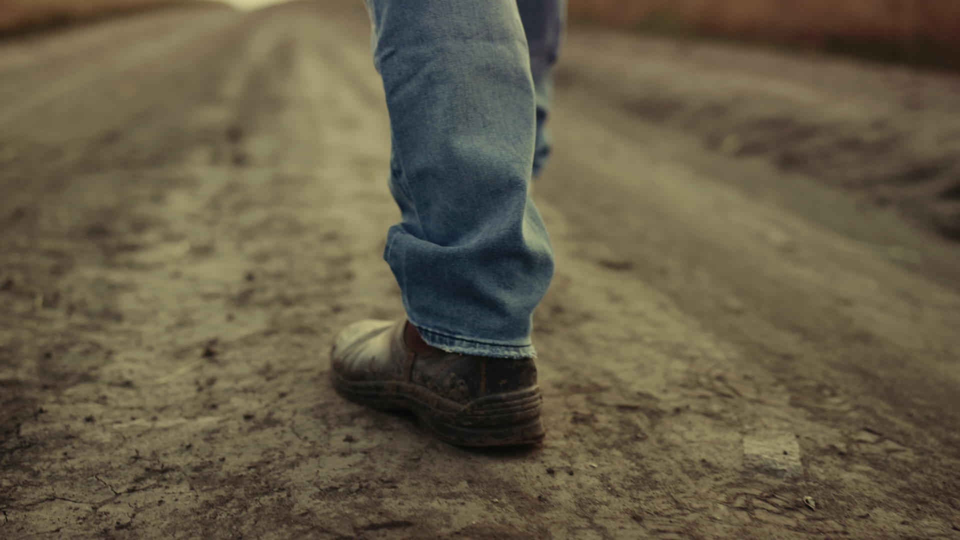 橡胶靴独自走在乡下乡间小路上视频的预览图