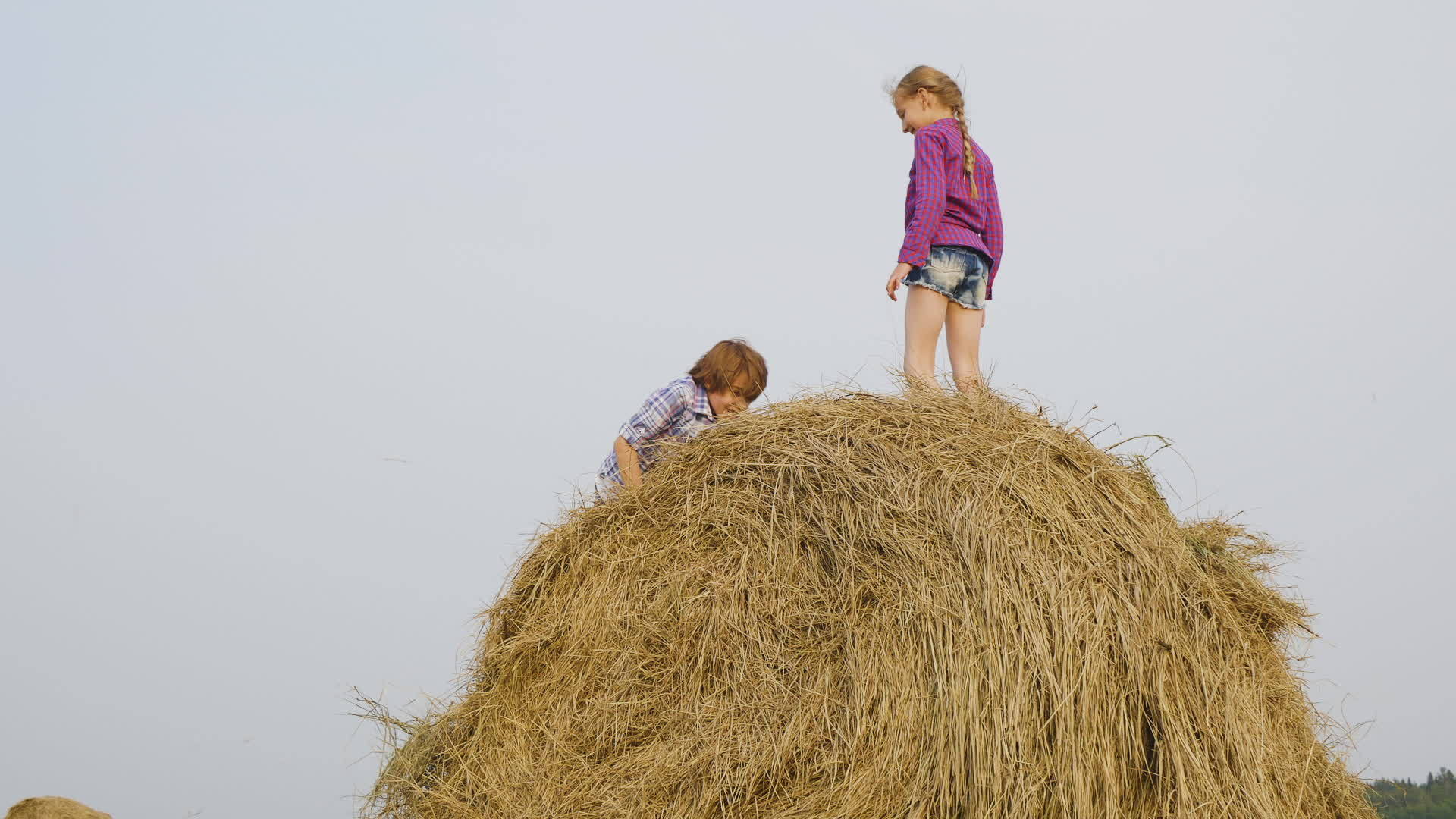 快乐的女孩站在农村的干草堆上视频的预览图